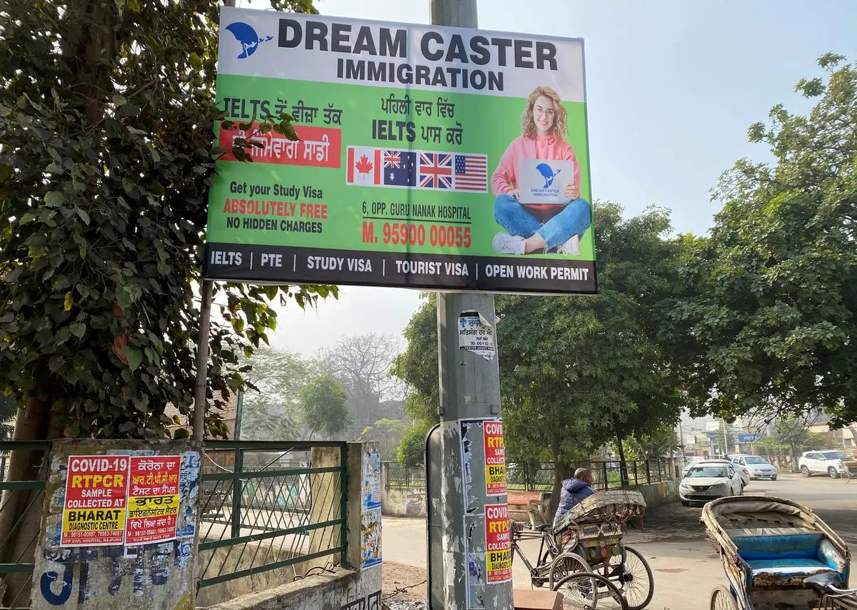 The larger issue involves the reasons why young people in Punjab are using desperate means to go abroad. In this image, a large poster of an immigration consulting agency lures hopefuls in Rajpura town in Punjab, in 2022.