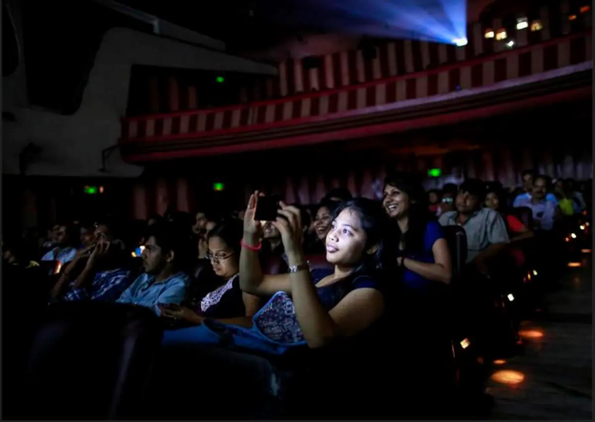 A cinema goer takes a picture in a hall screening Dilwale Dulhania Le Jayenge. 