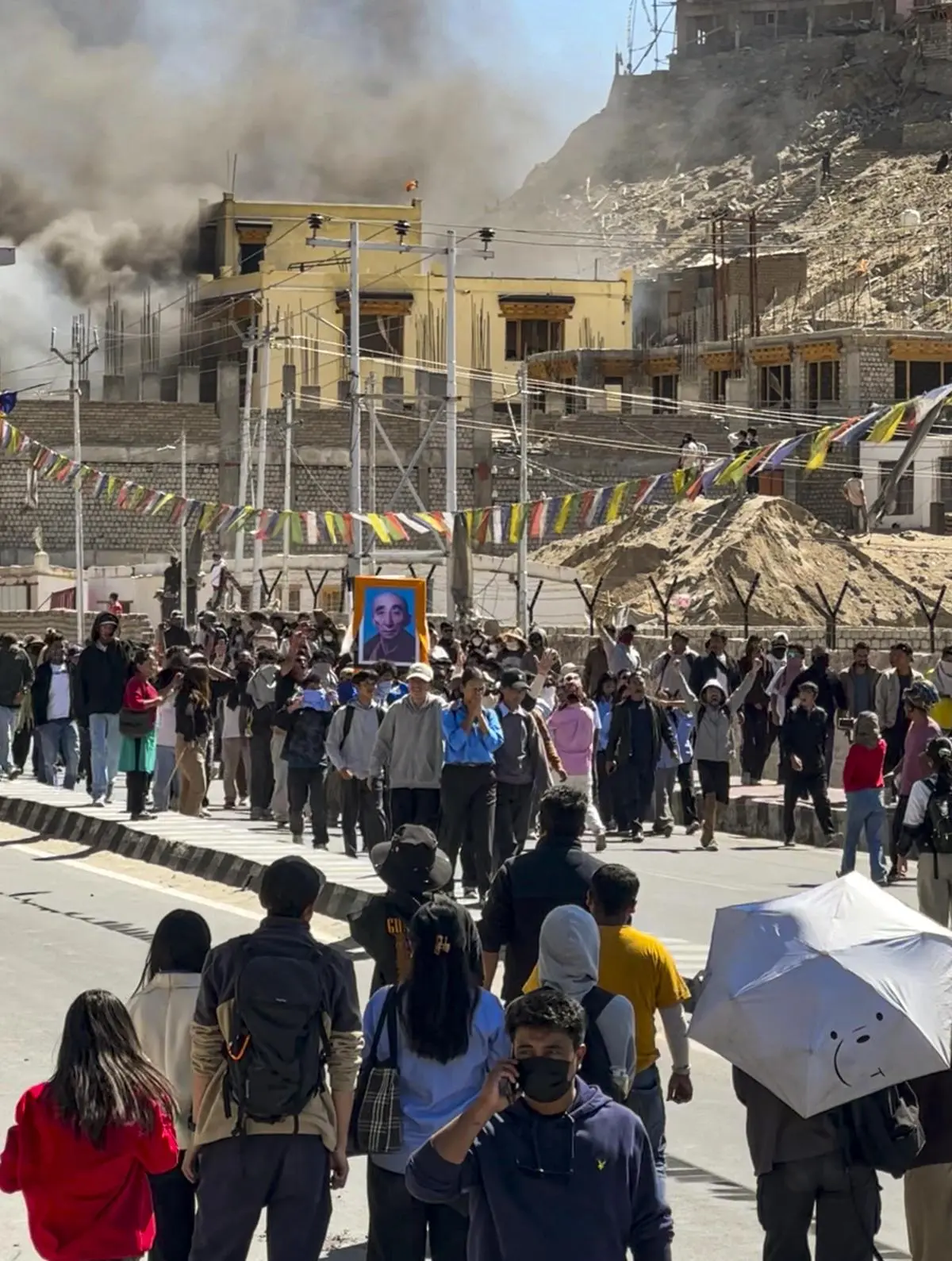 People of Leh gather outside the BJP office building, which was set ablaze by protesters on September 24, 2025, during a demonstration demanding statehood for Ladakh.