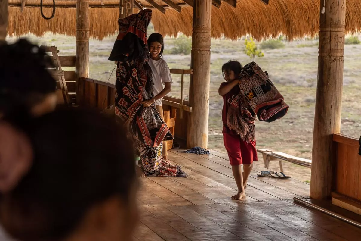 Children helping out at the community weaving centre. 