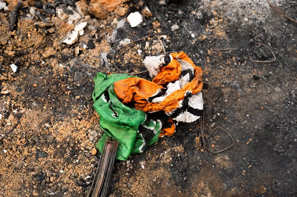 The flag of a political party lies among wreckage.  